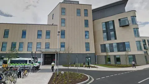 Entrance to Southmead Hospital's A&E department with ambulance and workers outside