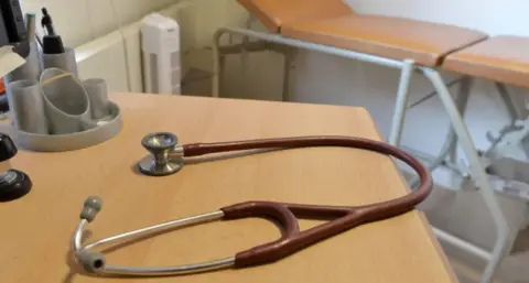PA Media A doctor's stethoscope on a table in a GP consultation room
