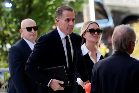 Reuters Hunter Biden, flanked by security and his wife, walks outside a courthouse in Wilmington, Delaware