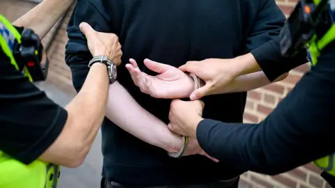 Police officers demonstrate the arrest a man during a patrol of the streets.