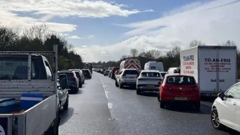 Several vehicles in a queue on the M5 carriageway, southbound, in Devon