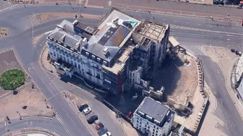 Britannia Hotels The Royal Albion Hotel, seen from above. Part of the site is empty where buildings have been demolished. The edge of the building still appears damaged by fire.