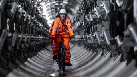 Engineers cycling down a tunnel