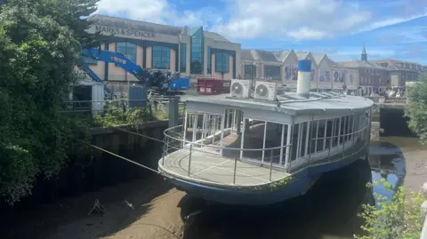 Old paddle steamer with big blue digger behind