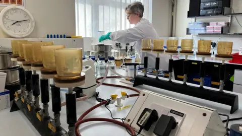 Jonah Fisher Laboratory for Water Quality Testing Image shows a woman and testing equipment