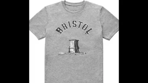 BANKSY A grey T-shirt with Bristol written above an empty plinth