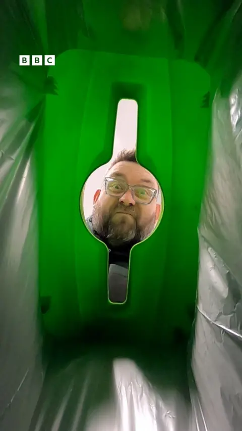 A man looks into a bin