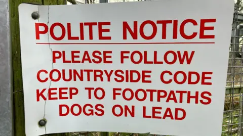 Sign on farm gate asking owners to keep dogs on leads