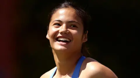 Emma Raducanu smiles after completing her opening victory at Queen's