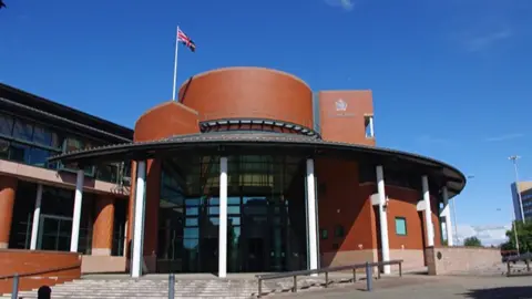 General view of the red-bricked and modern Preston Crown Court, on a sunny day with a blue sky