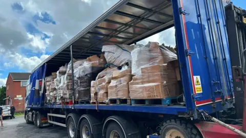 Bolton Council Lorries filled with cardboard boxes of goods.