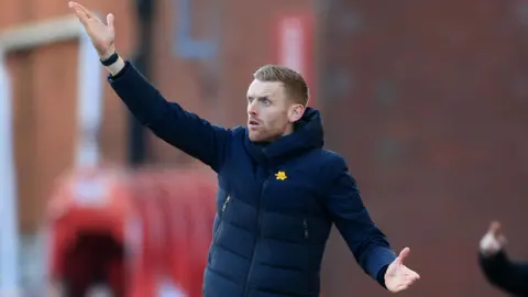 Ed Still on the touchline at a match, waving his arms