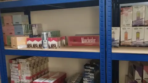 Westminster City Council Cigarettes and single-use vapes on a shelf.