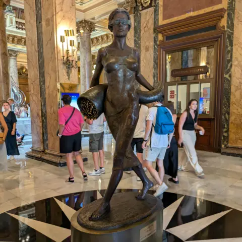 Vicky Baker A bronze statue of a blindfolded woman pouring coins inside Monte Carlo Casino