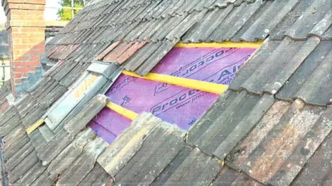 A roof with several tiles missing from it