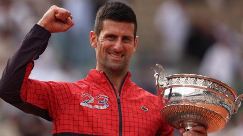 Novak Djokovic celebrates with the French Open trophy