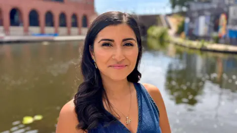 Summaya Mughal Summaya is wearing a denim summer top.