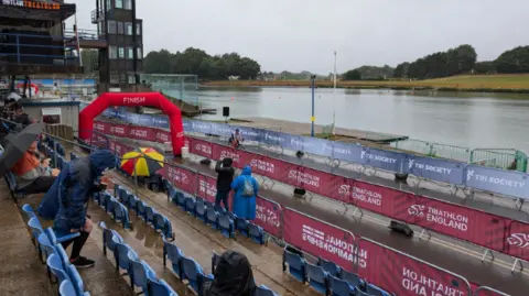 Fans at a seating area next to a lake at the water sports venue