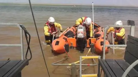 A lifeboat and three crew members.
