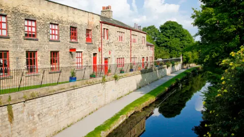 Leeds City Council Leeds Industrial Museum is a low two-storey building in stone with red window and door frames and sits alongside the Leeds Liverpool Canal