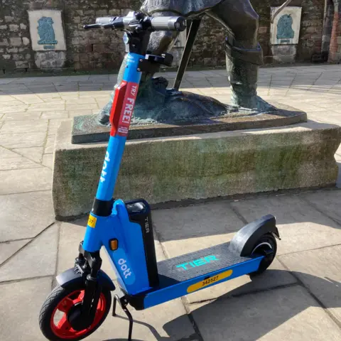 A blue e-scooter operated by the company Dott shown near Nottingham Castle. 