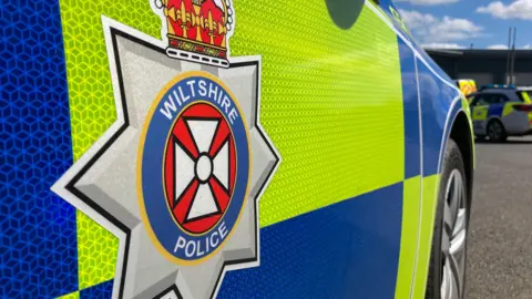 BBC Close-up of the side of a Wiltshire Police car. A generic shot showing the logo.