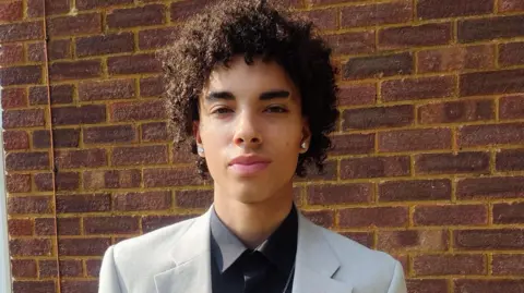 CONTRIBUTED Kyle Prosper looks directly into the camera. He is wearing a suit with a black tie.