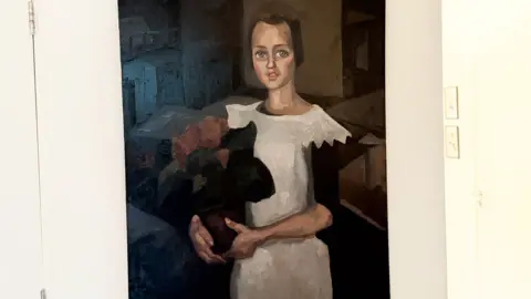 Arthur Brand A painting believed to be Toon Kelder's 'Portrait of a Young Girl' shows a girl in a white dress with black sleeves holding what appears to be a bouquet of red flowers. She has brown hair and blue eyes and is sitting.