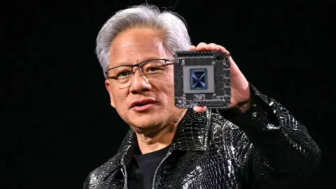 Nvidia CEO Jensen Huang delivers a keynote address at the Consumer Electronics Show while holding a Nvidia chip