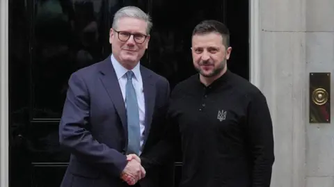 Standing outside of No10 Downing Street, Prime Minister Sir Keir Starmer (on the left) shakes hands with Ukrainian President Volodomyr Zelensky