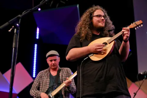 Two members of Elephant Sessions playing their instruments.