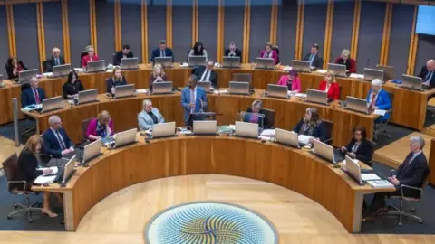 Senedd Commission Senedd politicians in the debating chamber