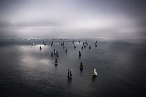 LOIC VENANCE / AFP Sailing boats leaving the coast