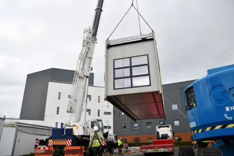 NHS Forth Valley A Portacabin modular gathering  being taken from a lorry and enactment     connected  to the grounds of NHS Forth Valley arsenic  portion  of plans to physique  the delayed inpatient ward