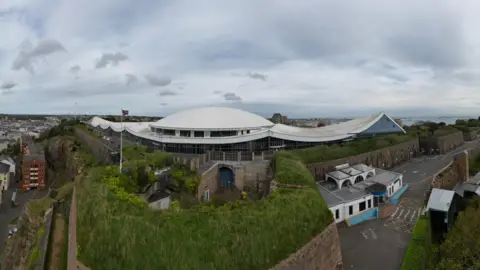 Aerial photo of Fort Regent with a white domed roof and surrounded by walled grounds