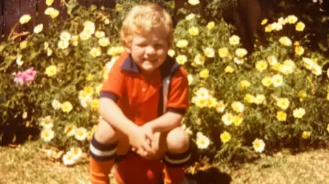 David Burton David Burton wearing a Luton kit as a child and sat on a football
