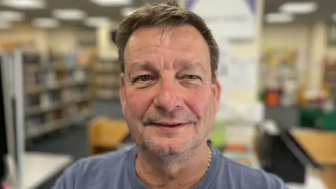 Christopher Weston standing in Park Library with stubble and short light brown hair.