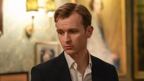 A man, the character Robert (played by Harry Lawtey) looking pensive in the TV show Industry