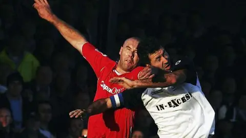 Getty Images Aaron Cook (right) heading the ball in a game where he is wearing the Salisbury City kit.