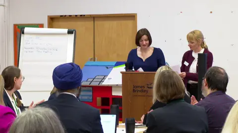 Bridget Phillipson stands in front of a group of people in a room as she prepares to make a speech.