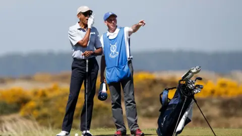 Getty Images Barak Obama with a caddy on a golf course