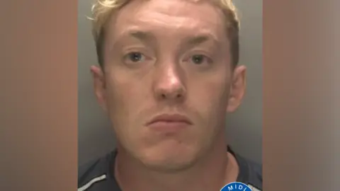 Callum Russell pictured in a mug shot. He short blonde hair and is clean shaven.