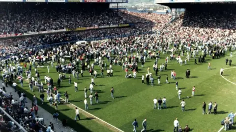 Hillsborough Inquests Fans on the pitch alongside a lone white ambulance near the goalmouth after a crush at the 1989 FA Cup semi-final at Hillsborough.