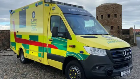 Guernsey ambulance - a yellow and green vehicle with St John written on the side