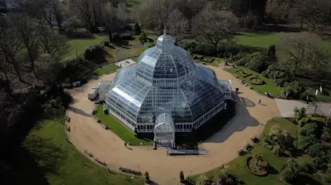 EPA An aerial shot of the Palm House, a domed glass conservatory surrounded by parkland in Sefton Park.