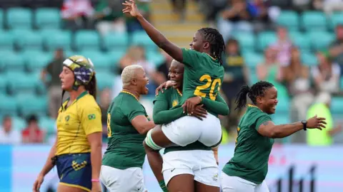 Andrew Boyers/Reuters South Africa's Vainah Ubisi celebrates with Lerato Makua - in white shorts and green tops - at the end of a match in Northampton against Brazil - Sunday 24 August 2025.