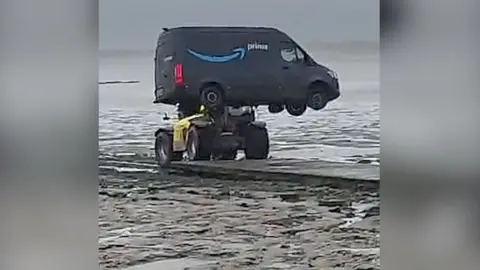 Amazon van lifted up by a yellow telehandler