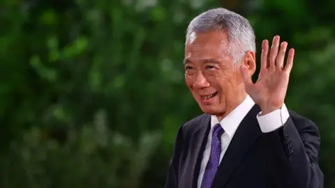 Getty Images Singapore's former prime minister Lee Hsien Loong gestures during the swearing-in ceremony of his successor Lawrence Wong at the Istana in Singapore on May 15, 2024. 