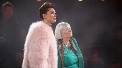 Mike Marsland/WireImage Widdecombe on stage after Big Brother. She is wearing a turqoise dress and shawl. 
