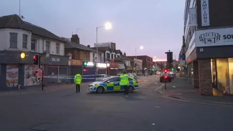 Vince Godwin A photo of Southchurch Road in Southend-on-Sea following the incident. The road has been cordoned off with police tape. A police car can be seen within the cordon and there are two officers on the scene. 